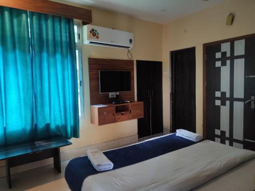 1 dormitorio con 1 cama y TV. en Hotel Tawang en Tawang