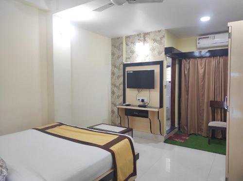 ein Hotelzimmer mit einem Bett und einem TV in der Unterkunft Hotel Tawang in Tawang