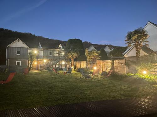a yard at night with a group of houses at La Sapinière in Saint-Laurent-sur-Mer