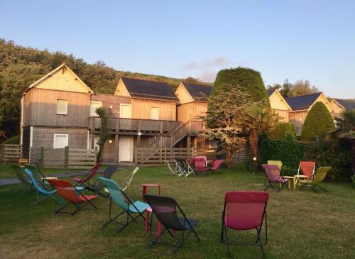 a group of chairs in the grass in front of a house at La Sapinière in Saint-Laurent-sur-Mer