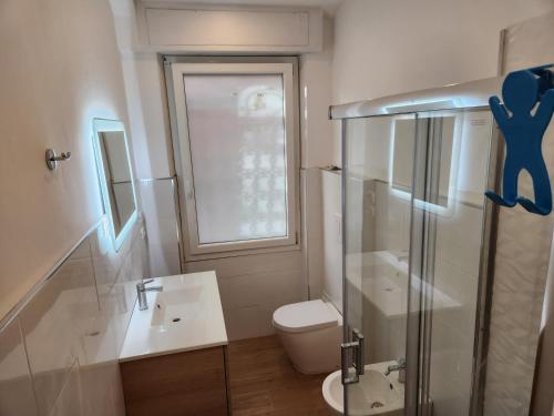 uma casa de banho com um WC e uma cabina de duche em vidro. em corso francia suite em Roma