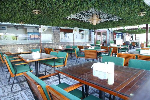 a restaurant with tables and chairs and ivy on the ceiling at Zenith Smart Vacation Homes, Sharjah in Sharjah