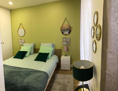 - une chambre avec 2 lits et un mur vert dans l'établissement LÉchappée Belle Métro 9 WiFi-Clim-NETFLIX, à Montreuil