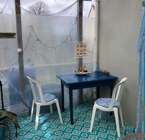 a blue table and two chairs in a room at chambre océan in Pleurtuit