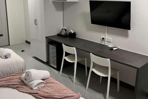 a room with a desk with two chairs and a television at Comfort Inn Centrepoint Motel in Lismore