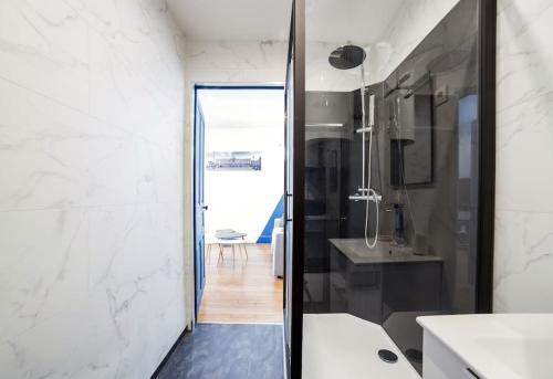 a bathroom with a black and white shower and a sink at P'tit Dupont F3 Nancy Thermal Logements Insolites in Nancy
