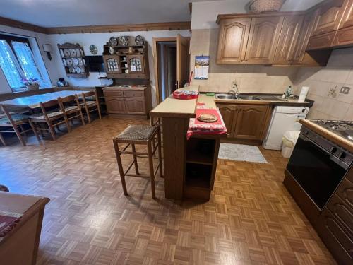 a kitchen with wooden cabinets and a dining room at Casa Ognano (Pellizzano) in Pellizzano