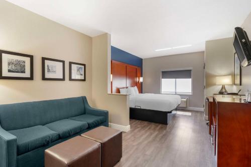 Comfort Suites West Jacksonville في جاكسونفيل: غرفة معيشة مع أريكة وسرير في غرفة