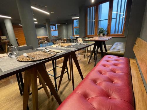 a dining room with tables and a red padded bench at Hotel Boka in Bovec
