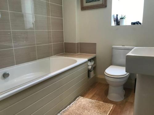 a bathroom with a tub and a toilet and a sink at A gorgeous, two double bedroom, period cottage. in Brasted