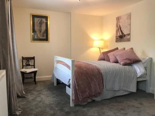 a bedroom with a large bed and a lamp at A gorgeous, two double bedroom, period cottage. in Brasted