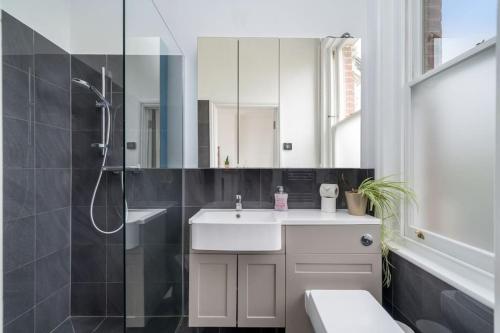 a bathroom with a sink and a shower and a toilet at Stunning house near Notting Hill in London