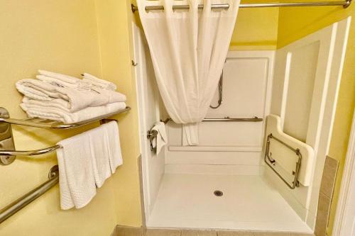 uma casa de banho com um espelho e toalhas brancas em Suburban Studios Fort Myers Cape Coral em Fort Myers