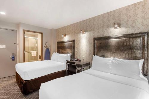 a hotel room with two beds with white sheets at Comfort Inn Manhattan - Midtown West in New York