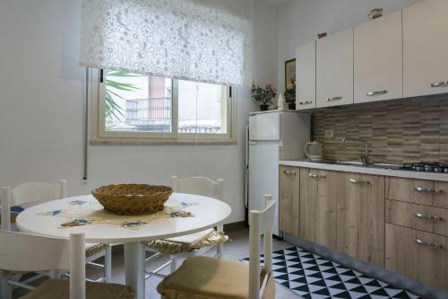 cocina con mesa, fregadero y nevera en Nonna Peppina Central Apartments, en Taormina