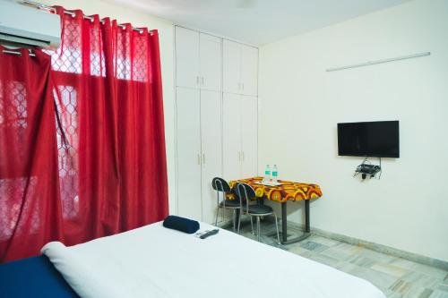 a room with a table and a red curtain at Hotel Green Villa - Near Anand Vihar Railway Station in New Delhi