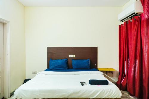 a bedroom with a bed with a red curtain at Hotel Green Villa - Near Anand Vihar Railway Station in New Delhi