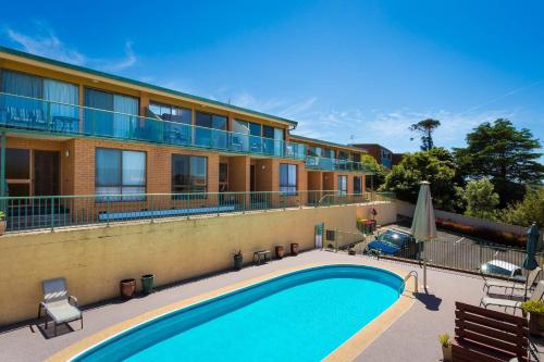 a swimming pool in front of a building at Panoramic Townhouses by Lisa in Merimbula