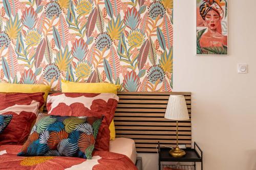 - une chambre avec un lit et du papier peint coloré dans l'établissement Oasis Urbaine Narbonne, à Narbonne