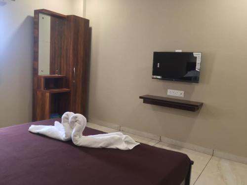 een zwaan gemaakt van handdoeken zittend op een bed bij Hotel Mint Leaf in Kāgal