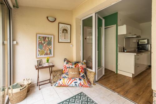 un salon avec un canapé et une cuisine dans l'établissement Oasis Urbaine Narbonne, à Narbonne