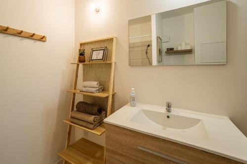 une salle de bain avec un lavabo et un miroir dans l'établissement Oasis Urbaine Narbonne, à Narbonne