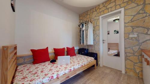 a bedroom with a bed with a laptop on it at Carpe Diem Apartment in Ivan Dolac