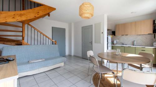 un salon avec un canapé bleu et une table dans l'établissement CAP CAMARGUE -F123- Appt lumineux 7 pers, au Grau-du-Roi