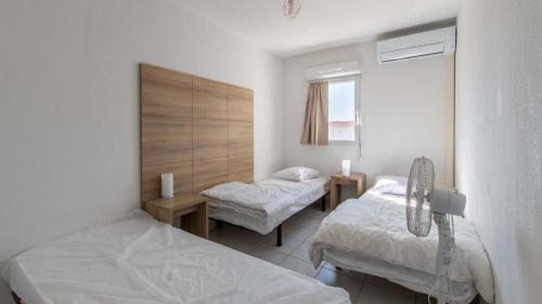 une chambre à l'hôpital avec deux lits et une fenêtre dans l'établissement CAP CAMARGUE -F123- Appt lumineux 7 pers, au Grau-du-Roi