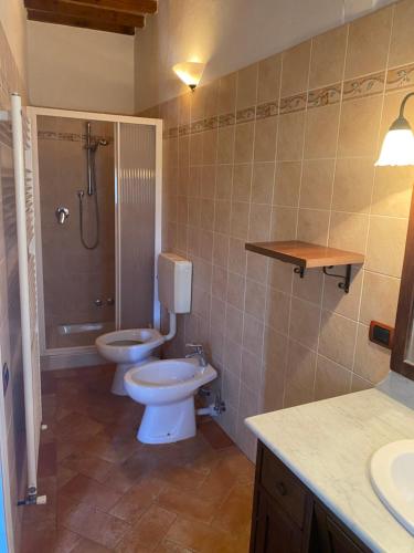 ein Badezimmer mit 2 WCs, einer Dusche und einem Waschbecken in der Unterkunft Casa di Poldo in Certaldo