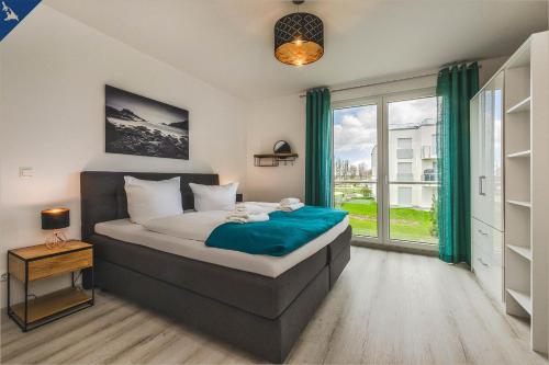 a bedroom with a bed and a large window at An der Haffküste Meerzeit in Zirchow