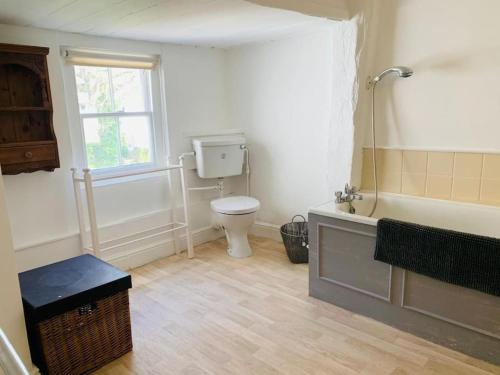 a bathroom with a toilet and a tub and a sink at 4 Bed 17th century Coach House in Brasted