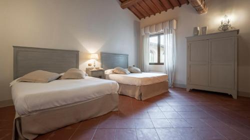 a bedroom with two beds and a window at Villa La Selva Wine Resort in Bucine