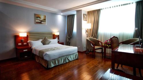 メケレにあるZEMARIAS INTERNATIONAL HOTELのベッドとデスクが備わるホテルルームです。