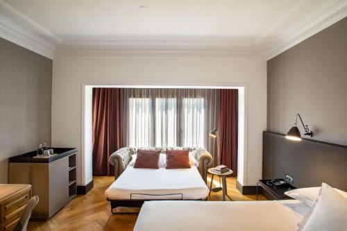 a hotel room with two beds and a window at Alexandra Barcelona Hotel, Curio Collection by Hilton in Barcelona