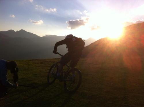 a man riding a bike on a hill at sunset at Mortirolo in Mazzo di Valtellina