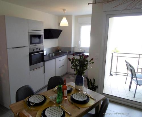 een keuken met een houten tafel met stoelen en een eetkamer bij Vue mer Sables d'Or in Frehel