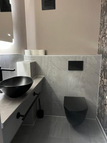 a bathroom with a black toilet and a sink at Pension Ottenheide in Schloß Holte-Stukenbrock