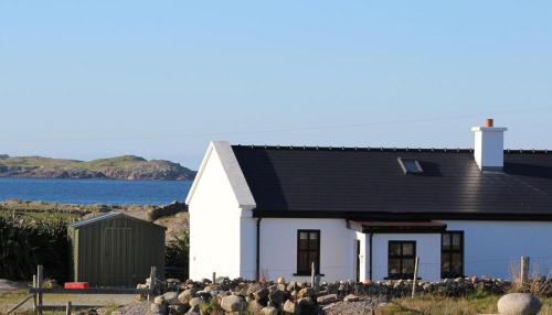 uma casa branca com um telhado preto em Claddaghduff 302 Gannoughs em Claddaghduff