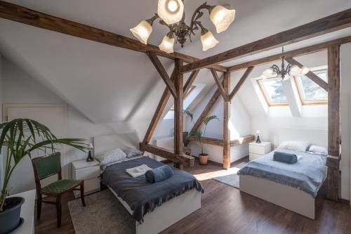 a attic bedroom with two beds and a chair at Giovanni's Airport House in Budapest