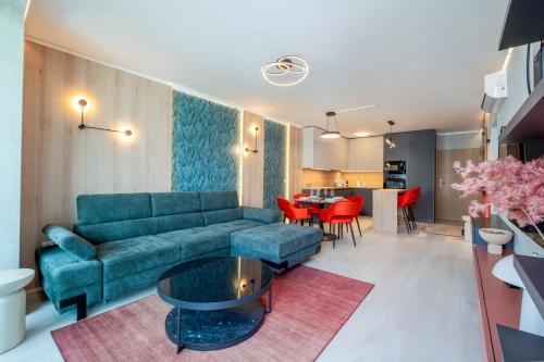 a living room with a blue couch and a table at MyFlat Wave Botanic Apartment in Siófok