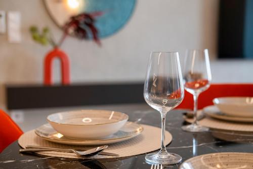 a table with plates and glasses of wine on it at MyFlat Wave Botanic Apartment in Siófok