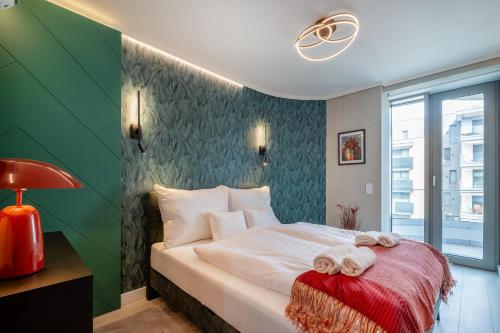 - une chambre avec un lit et des serviettes dans l'établissement MF Wave Botanic Apartment, à Siófok