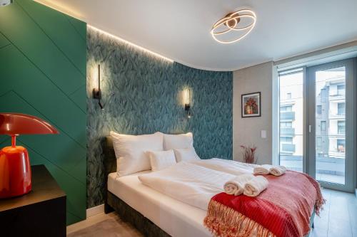 a bedroom with a bed with towels on it at MyFlat Wave Botanic Apartment in Siófok