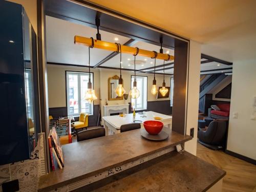a kitchen and living room with a table with a bowl on it at Duplex Jeanne d'Arc Billard Baby en option Escape Game Logements Insolites in Nancy