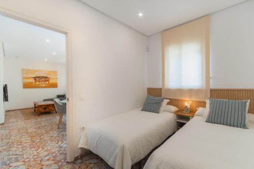 2 camas en una habitación con espejo en Manolete apartamento, en Jerez de la Frontera