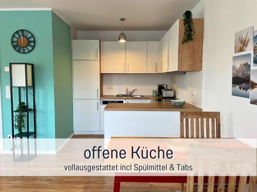 een open keuken met witte en groene muren bij Schönes Souterrain Apartment in Falkensee in Falkensee
