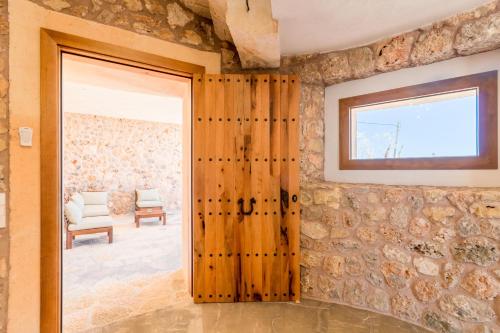 - une porte dans une pièce dotée d'un mur en pierre dans l'établissement Sa Pobla -2547 Mallorca, à Sa Pobla