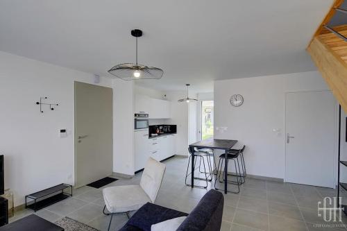 un salon avec une table et une cuisine dans l'établissement Pétunia - Proche Centre, à Fondettes