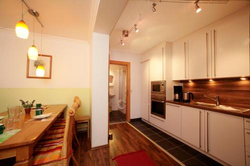 cocina con armarios blancos y encimera de madera en Appartement Bakker, en Kaprun